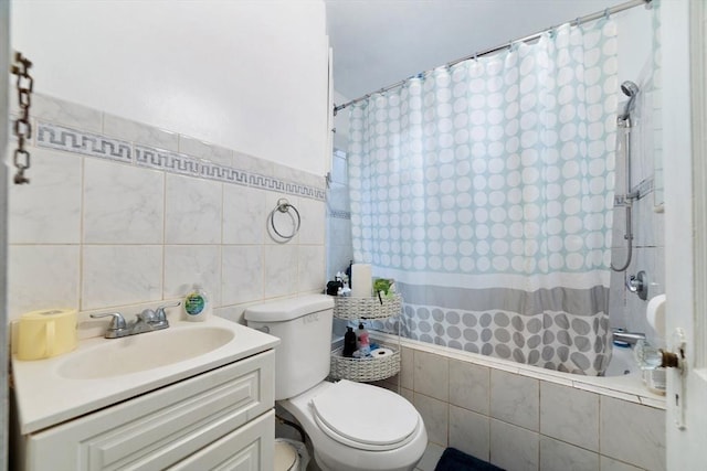 full bathroom with shower / tub combo with curtain, vanity, toilet, and tile walls