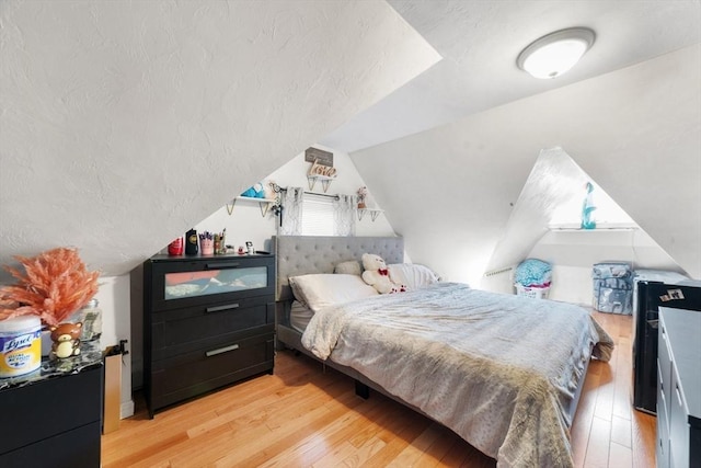 bedroom featuring lofted ceiling and light hardwood / wood-style floors