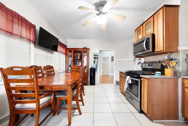 kitchen featuring light tile patterned flooring, ceiling fan, stainless steel appliances, and tasteful backsplash