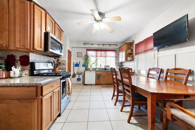 kitchen with sink, light tile patterned floors, ceiling fan, stainless steel appliances, and decorative backsplash