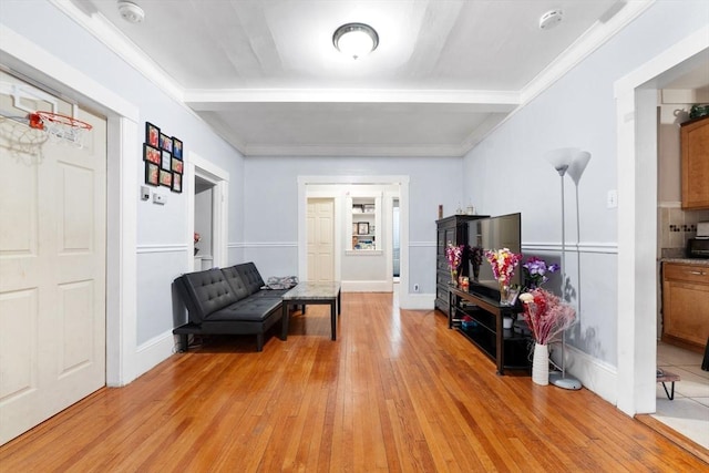 sitting room featuring beam ceiling and light hardwood / wood-style flooring