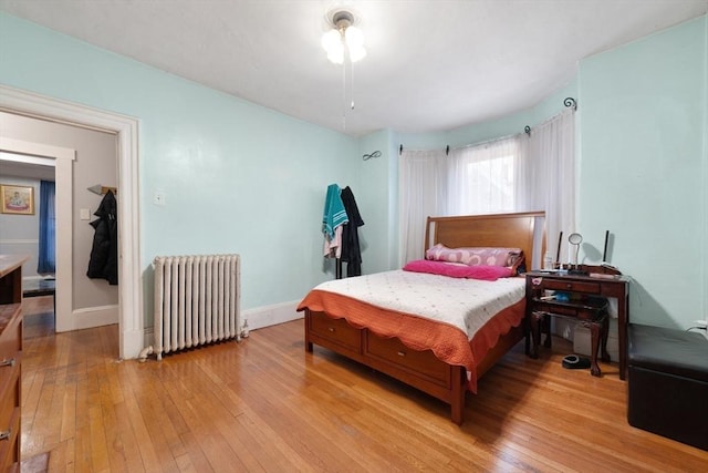 bedroom with radiator and light hardwood / wood-style floors