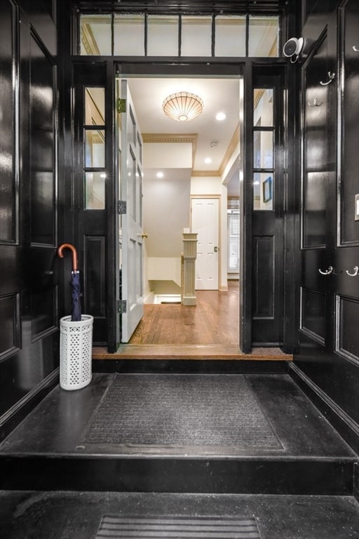 entrance foyer with crown molding and hardwood / wood-style flooring