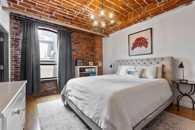 121-123 Beach St Unit 603, Boston, MA 02111 - bedroom featuring brick ceiling, multiple windows, light wood-style flooring, brick wall, and a chandelier