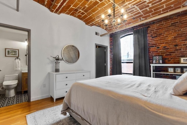 121-123 Beach St Unit 603, Boston, MA 02111 - bedroom with brick ceiling, baseboards, wood finished floors, ensuite bathroom, and a chandelier