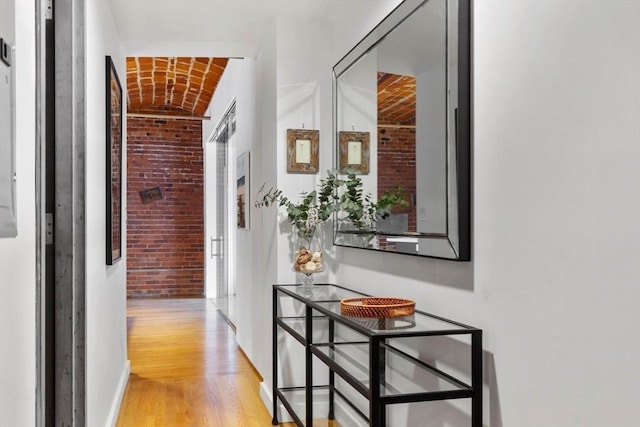 121-123 Beach St Unit 603, Boston, MA 02111 - hall with brick wall, light wood-style flooring, brick ceiling, and baseboards
