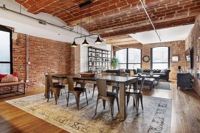 121-123 Beach St Unit 603, Boston, MA 02111 - dining space featuring brick ceiling, wood-type flooring, and brick wall