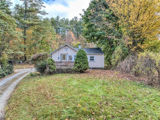 view of side of property featuring a yard and a deck