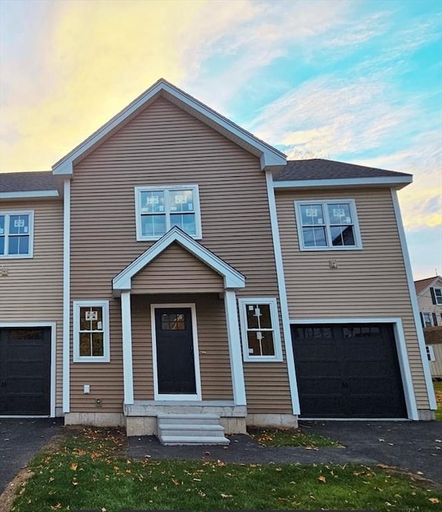 townhome / multi-family property with driveway, an attached garage, and entry steps