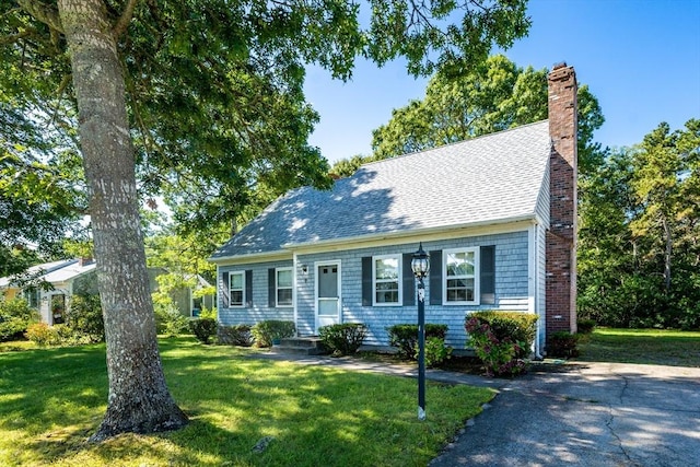 cape cod house featuring a front lawn