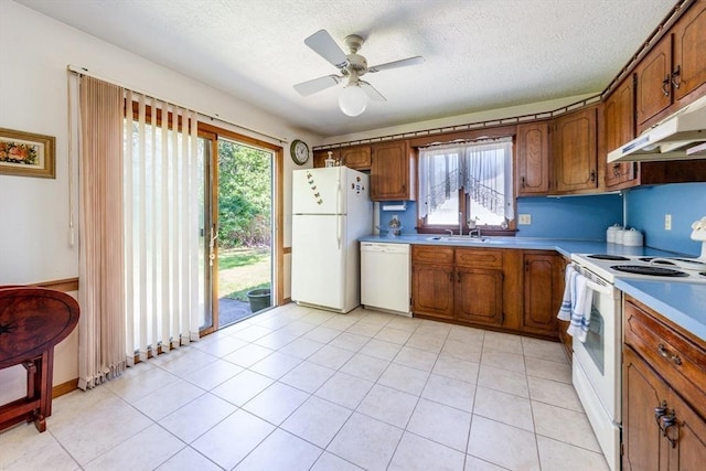 kitchen featuring ceiling fan, sink, a textured ceiling, white appliances, and light tile patterned floors