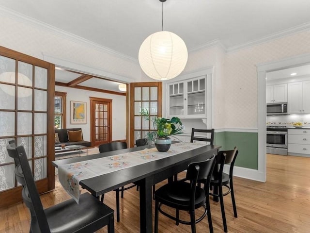 161 Playstead Rd, Medford, MA 02155 - dining area with light wood-style floors, wallpapered walls, crown molding, and french doors