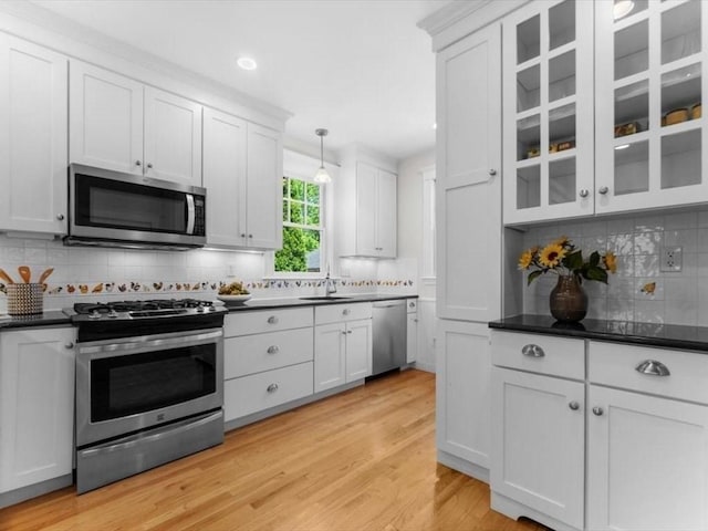 161 Playstead Rd, Medford, MA 02155 - kitchen with appliances with stainless steel finishes, backsplash, dark countertops, light wood-style flooring, and recessed lighting