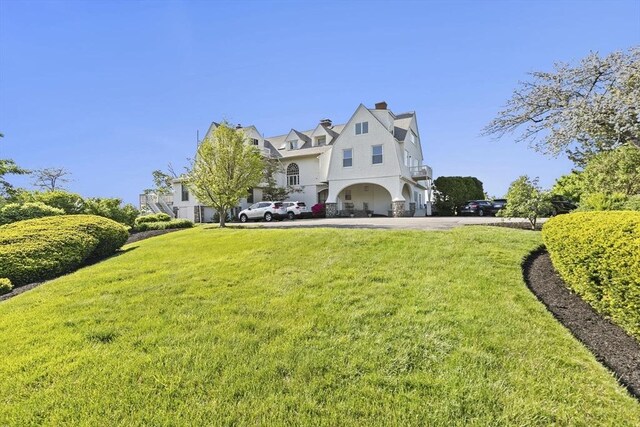 646 Jerusalem Rd Unit 7, Cohasset, MA 02025 - view of front of house with a front lawn, stucco siding, a chimney, and a balcony
