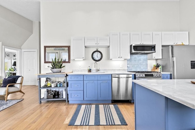 646 Jerusalem Rd Unit 7, Cohasset, MA 02025 - kitchen featuring stainless steel appliances, a sink, white cabinets, light wood-style floors, and high vaulted ceiling