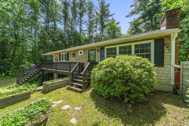 255 State St, Belchertown, MA 01007 - view of front of property featuring a vegetable garden, stairway, a chimney, and a wooden deck