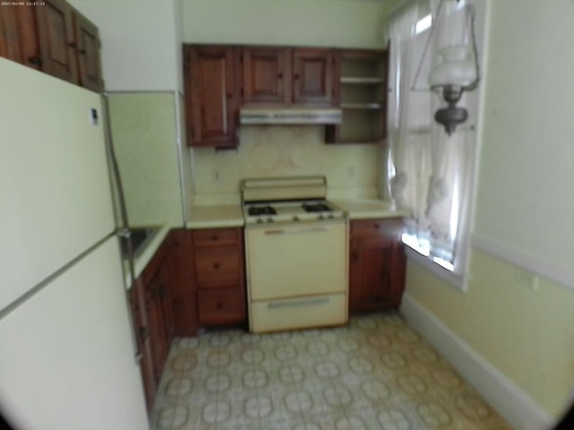 39 King St, Holyoke, MA 01040 - kitchen featuring white appliances, under cabinet range hood, light countertops, and brown cabinetry