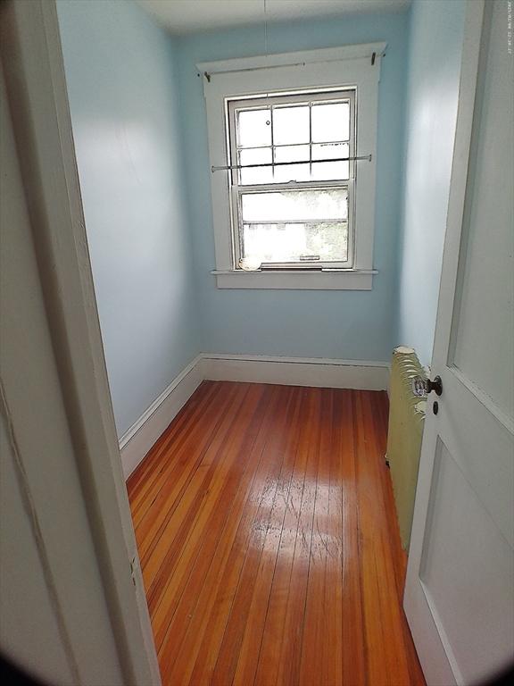 39 King St, Holyoke, MA 01040 - unfurnished room featuring radiator heating unit, hardwood / wood-style floors, and baseboards