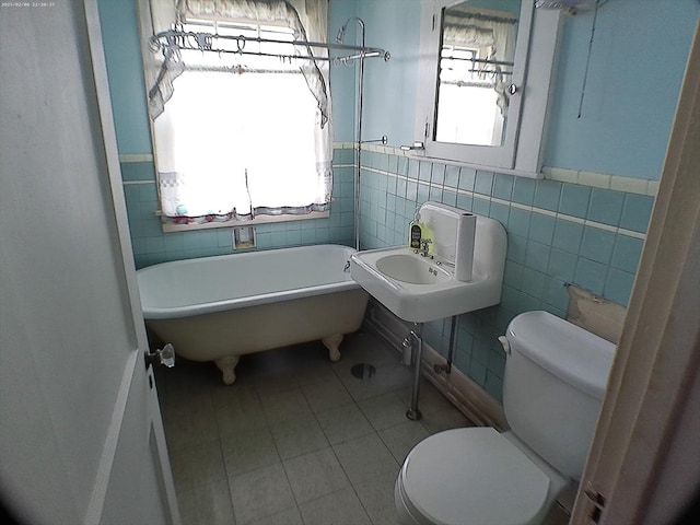 39 King St, Holyoke, MA 01040 - bathroom featuring toilet, a freestanding tub, tile walls, a sink, and a wainscoted wall