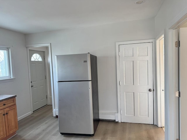 kitchen featuring stainless steel fridge and light hardwood / wood-style floors