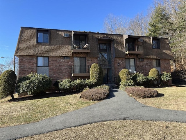 view of front of house with a balcony and a front lawn