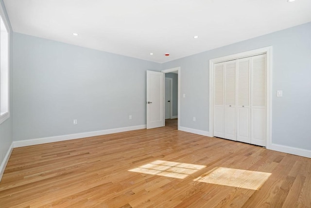 unfurnished bedroom with light wood finished floors, baseboards, a closet, and recessed lighting