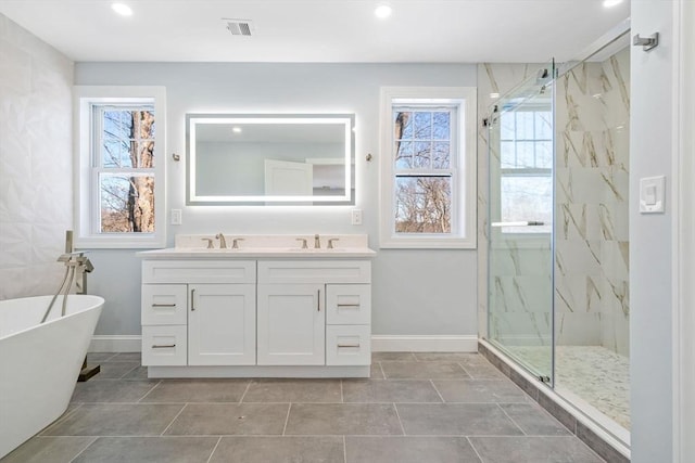 bathroom with baseboards, a sink, a marble finish shower, and double vanity