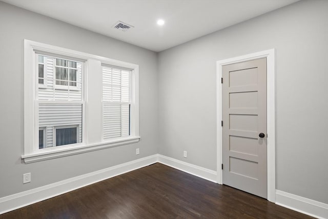 empty room featuring recessed lighting, baseboards, visible vents, and dark wood finished floors