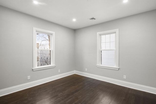 spare room featuring baseboards, dark wood-type flooring, recessed lighting, and visible vents