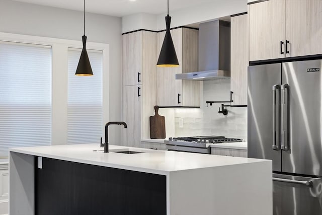 kitchen featuring a sink, modern cabinets, wall chimney range hood, light countertops, and high end refrigerator