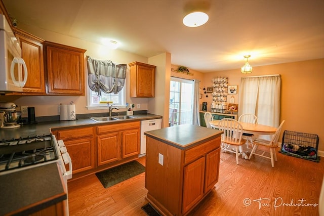 115 Arnold St, Fall River, MA 02724 - kitchen featuring dark countertops, a sink, light wood-style flooring, and white appliances