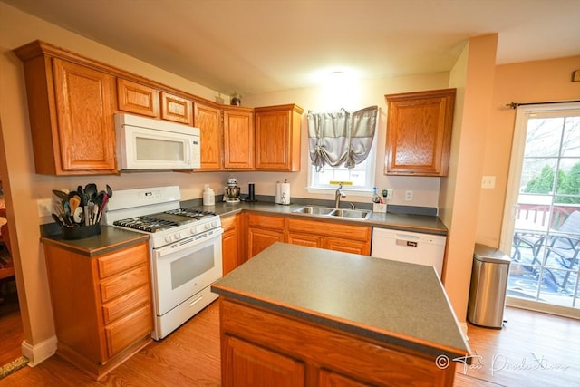 115 Arnold St, Fall River, MA 02724 - kitchen featuring white appliances, a wealth of natural light, light wood-style floors, dark countertops, and a sink