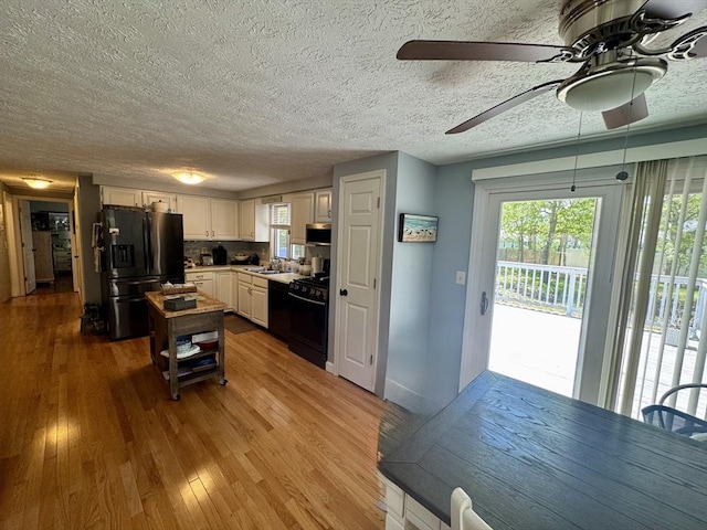 39 Pine Grove Rd, Yarmouth, MA 02664 - kitchen with black appliances, ceiling fan, hardwood / wood-style floors, white cabinetry, and a textured ceiling