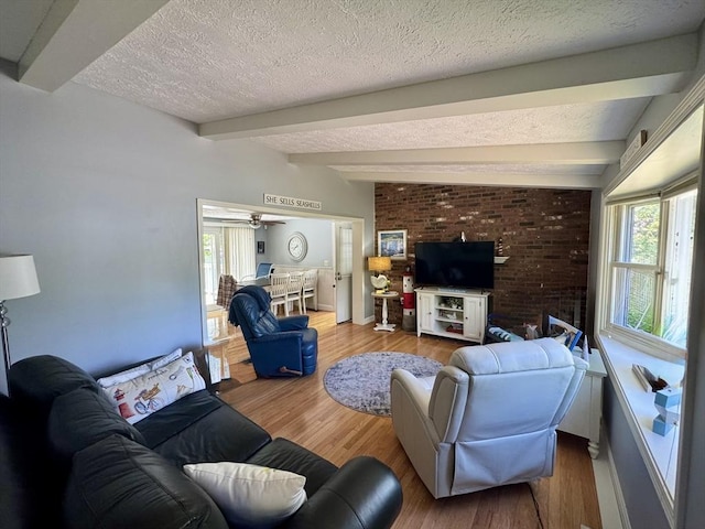 39 Pine Grove Rd, Yarmouth, MA 02664 - living room with beamed ceiling, wood finished floors, a textured ceiling, a ceiling fan, and baseboards