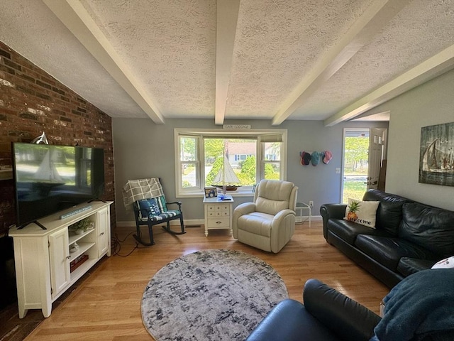 39 Pine Grove Rd, Yarmouth, MA 02664 - living area with a textured ceiling, beam ceiling, light wood finished floors, and baseboards
