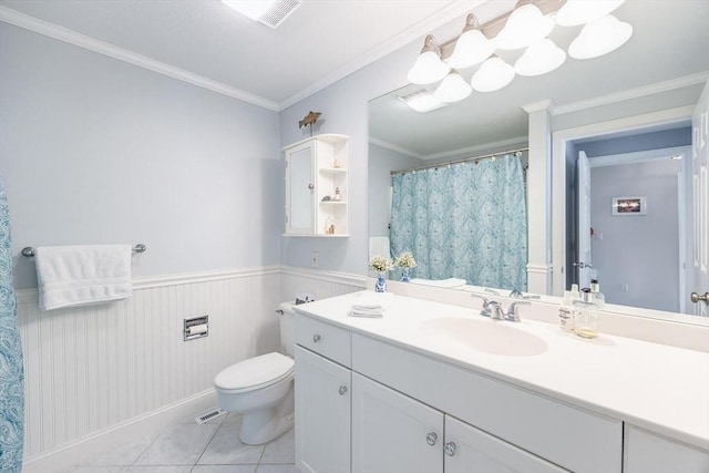 full bathroom featuring toilet, ornamental molding, tile patterned flooring, and a wainscoted wall
