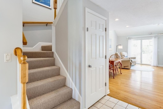 staircase with baseboards, recessed lighting, and wood finished floors