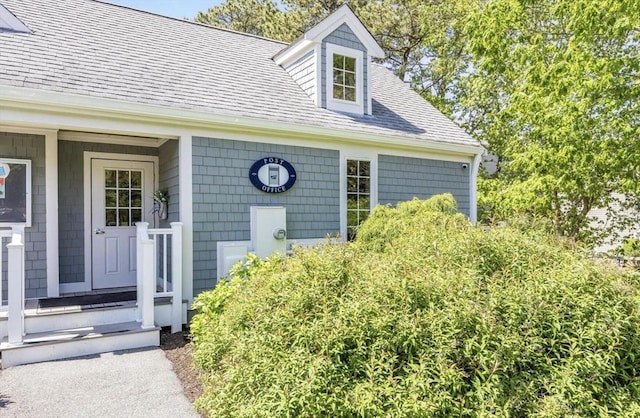 property entrance featuring roof with shingles