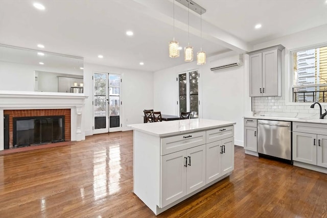 kitchen featuring backsplash, a fireplace, pendant lighting, an AC wall unit, and dishwasher