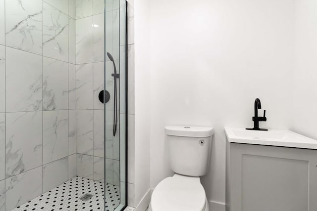 bathroom featuring vanity, toilet, and tiled shower