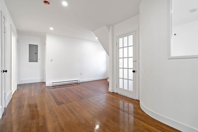 spare room with electric panel, baseboard heating, and dark hardwood / wood-style floors