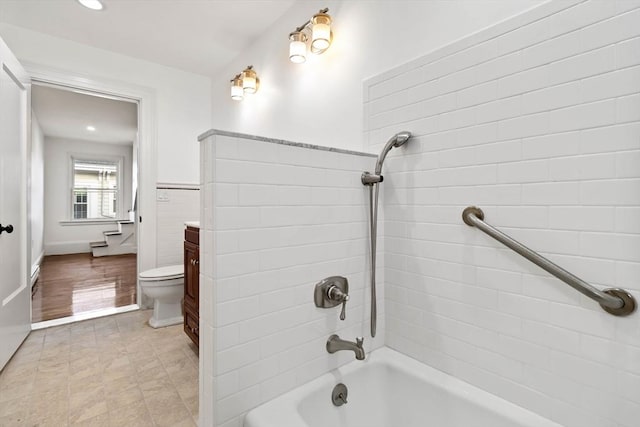 full bathroom featuring vanity, toilet, tile walls, and tiled shower / bath combo