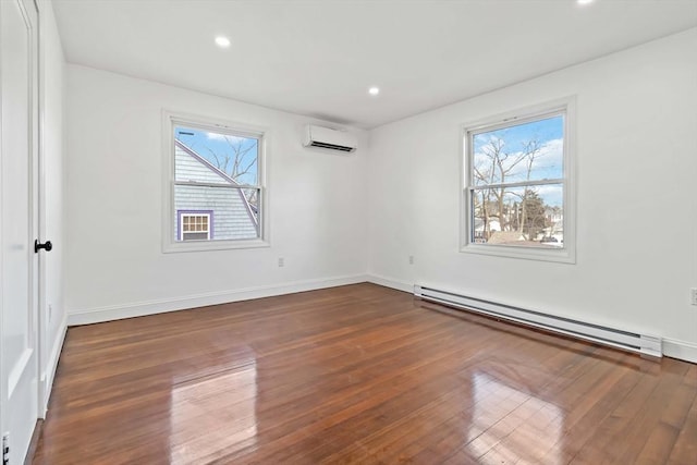 empty room featuring baseboard heating, a wall mounted AC, and dark wood-type flooring