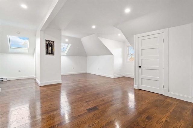 bonus room with dark hardwood / wood-style floors, plenty of natural light, and lofted ceiling with skylight