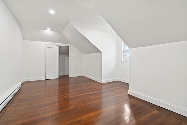 bonus room with dark wood-type flooring, vaulted ceiling, and a baseboard heating unit