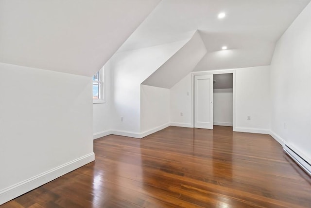 bonus room with dark hardwood / wood-style floors, lofted ceiling, and a baseboard heating unit