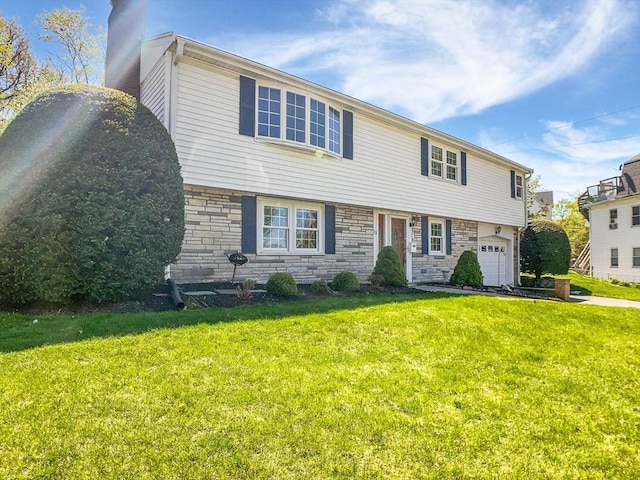 view of front of house featuring an attached garage, a chimney, stone siding, and a front yard