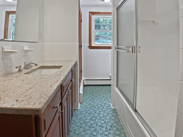 bathroom with tile walls, a baseboard radiator, wainscoting, tile patterned floors, and vanity