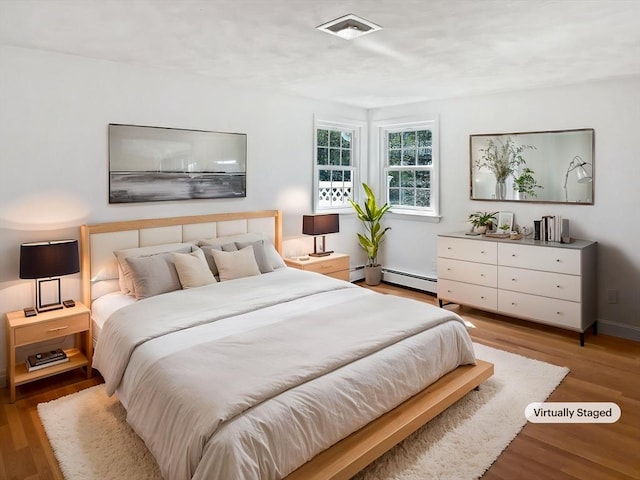 bedroom featuring visible vents and wood finished floors