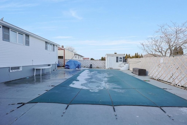 view of pool featuring a fenced backyard, an outdoor structure, and a storage unit